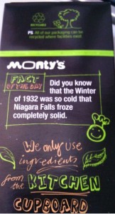 The image shows the back of a product package from a brand called Monty's. The package features a "Fact of the Day" which states: "Did you know that the Winter of 1932 was so cold that Niagara Falls froze completely solid." The package also mentions that the brand uses ingredients from the kitchen cupboard. There are various doodles and illustrations, including a smiling face, leaves, and a tree. The top of the package has a note about recycling, indicating that all packaging can be recycled where facilities exist.