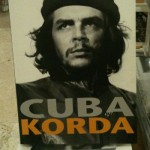 The image is a black and white photograph of a man wearing a beret, with the text "CUBA" in large gray letters and "KORDA" in large orange letters below the photograph.