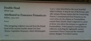 The image shows a museum placard with information about a sculpture titled "Double Head," created around 1543. The sculpture is attributed to Francesco Primaticcio, an Italian artist who lived from 1504 to 1570. The placard explains that the sculpture was cast from the female head of the ancient marble statue "Cesi Juno" located in Rome's Capitoline Museums. It also mentions that the sculpture was commissioned by King Francis I of France and was part of a garden at Fontainebleau. The text highlights the sculpture's historical significance and its influence on various artists and designers, including Pierre Crozat and Yves Saint Laurent.