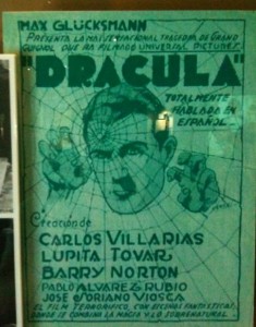 The image is a vintage movie poster for the film "Dracula." The poster is predominantly green and features an illustration of a man's face with a spider web pattern over it. The text at the top reads "Max Glücksmann presenta la monumental tragedia de Grand Guignol que ha filmado Universal Pictures: DRACULA totalmente hablada en español." Below the illustration, the cast is listed: "Carlos Villarías, Lupita Tovar, Barry Norton, Pablo Álvarez Rubio, José Soriano Viosca." The poster has a classic, old-fashioned design typical of early 20th-century cinema advertisements.