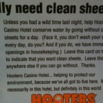 The image is a sign from Hooters Casino Hotel that reads:

"really need clean sheets?

Unless you had a wild time last night, help Hooters Casino Hotel conserve water by going without clean sheets for a day. (Face it, you don't wash your sheets every day, do you? And if you do, we have immediate openings in housekeeping.) Leave this card on the bed to indicate that you want clean sheets. Leave this card anywhere else if you can go without. Thanks.

Hooters Casino Hotel... helping to protect our environment, because we've all got to live here. Not necessarily in this hotel, but definitely in this world."

The Hooters logo is at the bottom of the sign.