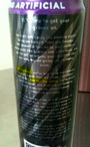 The image shows a close-up of a can with a purple top. The can has text on it, which appears to be a description of the product. The text mentions ingredients such as guava and passion fruit, and it seems to be promoting the drink as a natural energy booster. The text is partially obscured and difficult to read in some areas. The can also has a QR code near the bottom.