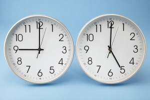 The image shows two analog clocks with white faces and black hands against a light blue background. The clock on the left shows the time as 9:00, while the clock on the right shows the time as 6:00.