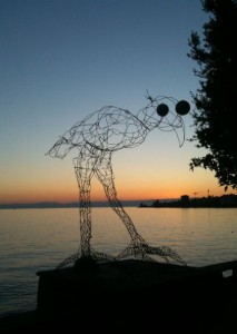 a sculpture of a bird with a body of water in the background