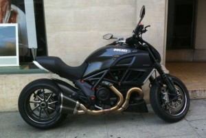 a black motorcycle parked on the sidewalk